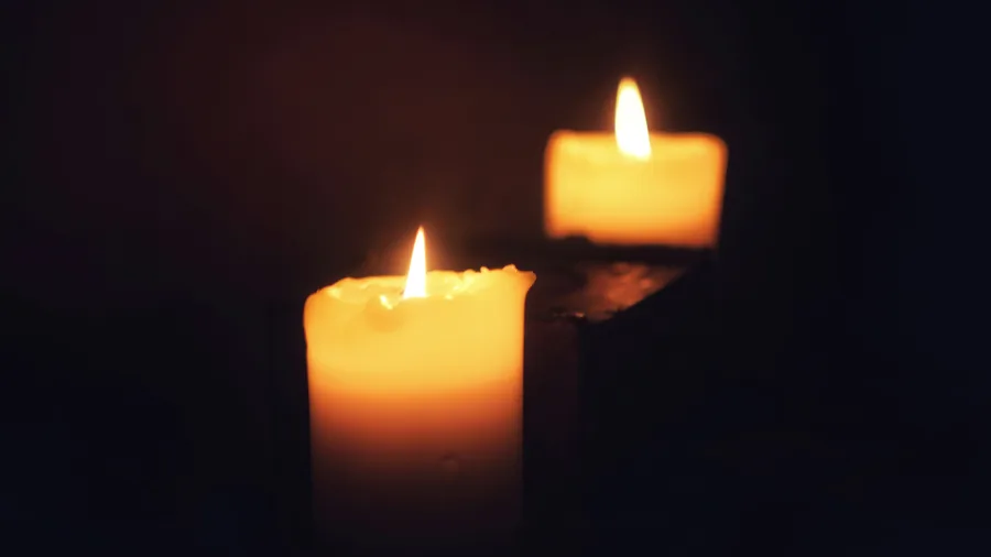 Lumânări aprinse într-un decor nocturn, cu atmosferă spirituală