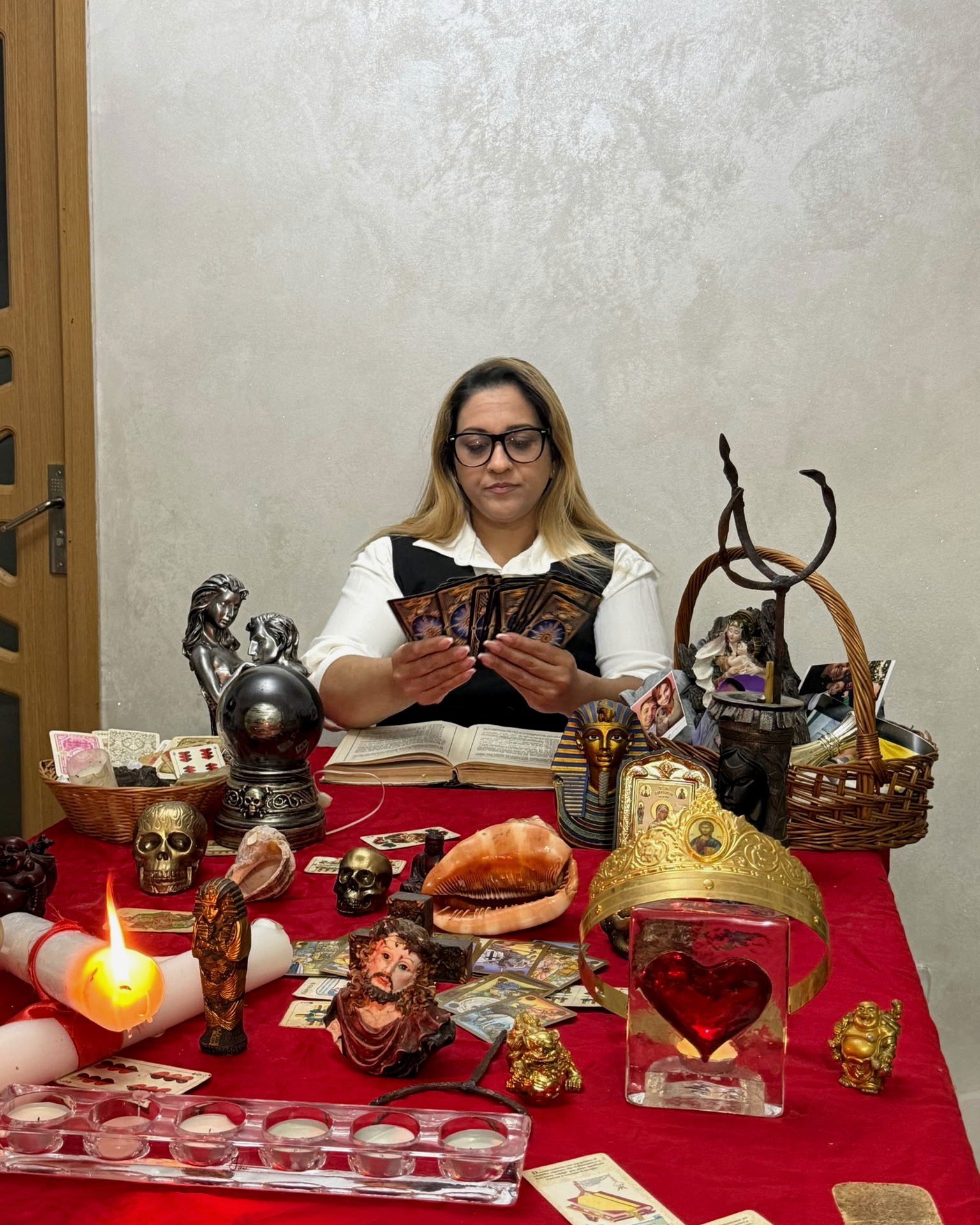 Tămăduitoarea Simona la masa de lucru, alături de cărți de tarot și obiecte spirituale